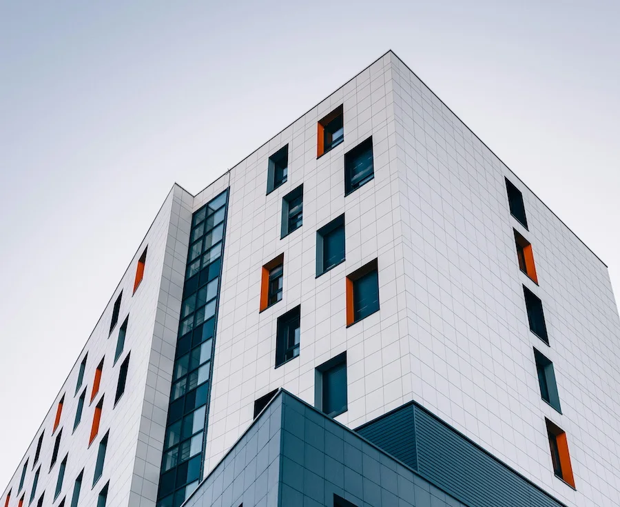 Moderne hvid bygning med orange vinduesdetaljer